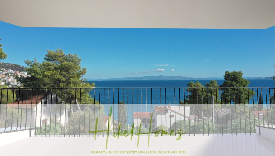 Luxus Meerblick 77m² Ensemble mit 2 Schlafzimmern, Terrasse und Südausrichtung - Blick von einem Balkon mit schwarzem Geländer auf das Meer, die Bäume und die Dächer unter einem klaren blauen Himmel. Der Text "Hikel Homes Traum & Ferienimmobilien in Kroatien" ist am unteren Rand eingeblendet. (45216)