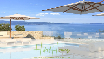 Der Infinity-Pool mit Liegestühlen und großen Sonnenschirmen bietet einen herrlichen Blick auf das blaue Meer und die fernen Berge unter einem klaren Himmel. Der Text "Hikel Homes Traum- & Ferienimmobilien in Kroatien" erscheint am unteren Rand. - Exklusive 380m² Meerblick & Luxus in absoluter Alleinlage mit Privatspähre + Pool, Sommerküche, …