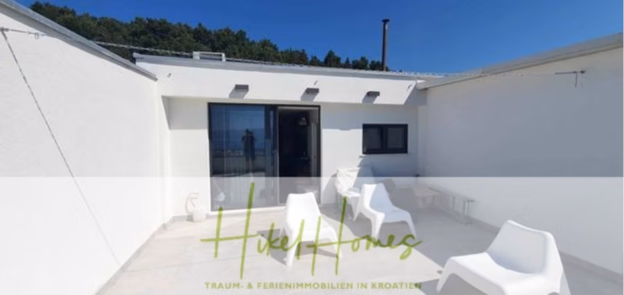 Charmantes 1-Zimmer-Appartement mit Meerblick im Herzen von Split mit Dachterrasse - Dachterrasse mit weißen, modernen Stühlen und einem kleinen Tisch auf hellem Fliesenboden. Große Glastüren führen ins Innere. Im Hintergrund sind grüne Hügel unter einem strahlend blauen Himmel zu sehen. Textüberlagerung: „Hotel Homes Traum- & Ferienimmobilien in Kroatien.“. (42230)