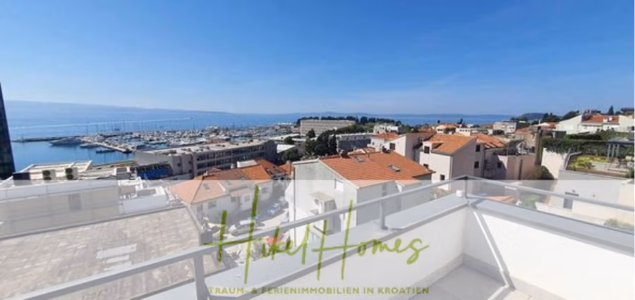 Charmantes 1-Zimmer-Appartement mit Meerblick im Herzen von Split mit Dachterrasse - Blick von einem Balkon auf einen Yachthafen mit zahlreichen angedockten Booten. Die Szene zeigt die Dächer von Wohnhäusern und im Hintergrund einen klaren, blauen Himmel. (42229)