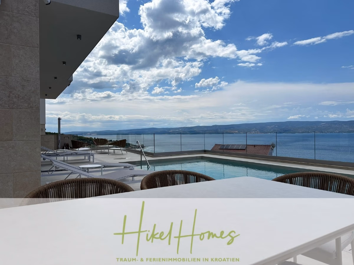 Moderne Terrasse mit Pool und Liegestühlen mit Blick auf das Meer unter einem teilweise bewölkten Himmel. Der Text "Hikel Homes Traum- & Ferienimmobilien in Kroatien" erscheint am unteren Rand. - Luxus pur! Jetzt einziehen und Sommer genießen! Schlüsselfertige Meerblick Villa, 3SZ, Pool, …