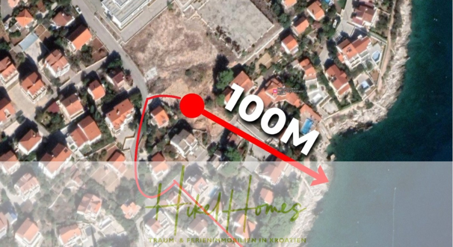 Luxus Meerblick 77m² Ensemble mit 2 Schlafzimmern, Terrasse und Südausrichtung – Einziehen 2025! - Luftaufnahme eines Küstenviertels mit Häusern mit roten Dächern. Ein roter Pfeil und ein Punkt zeigen die Entfernung von 100 Metern zwischen einem Haus im Landesinneren und der Wasserkante an. Der Text am unteren Rand lautet "Nikel Homes". (46461)