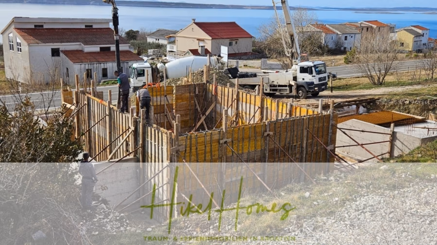 Neubau Meerblick 270m vom Meer entfernt – Hochwertigen Ausstattung – Fertigstellung Ende 2025 - Baustelle in Küstennähe mit mehreren Häusern. Arbeiter errichten eine Struktur aus Holz- und Metallgerüst. Im Hintergrund sind ein LKW und ein Kran zu sehen. Im Vordergrund ist das Logo „Hikel Homes“ mit dem Slogan darunter zu sehen. (42609)
