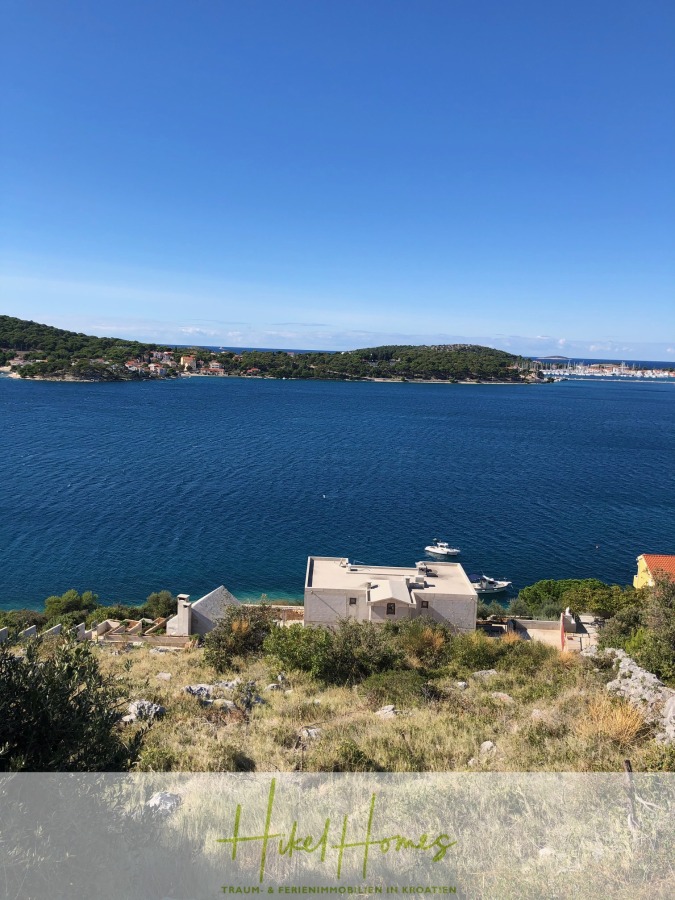 Luxus Villa Sunce / gegenüber Marina Frapa / Meerblick + direkter Meerzugang, Pool, mit 391m² WFL - Blick von einem Hügel auf ein tiefblaues Meer mit Booten, Hausdächern im Vordergrund und grünen Inseln und einer Stadt mit weißen Gebäuden in der Ferne unter einem klaren blauen Himmel. (45128)