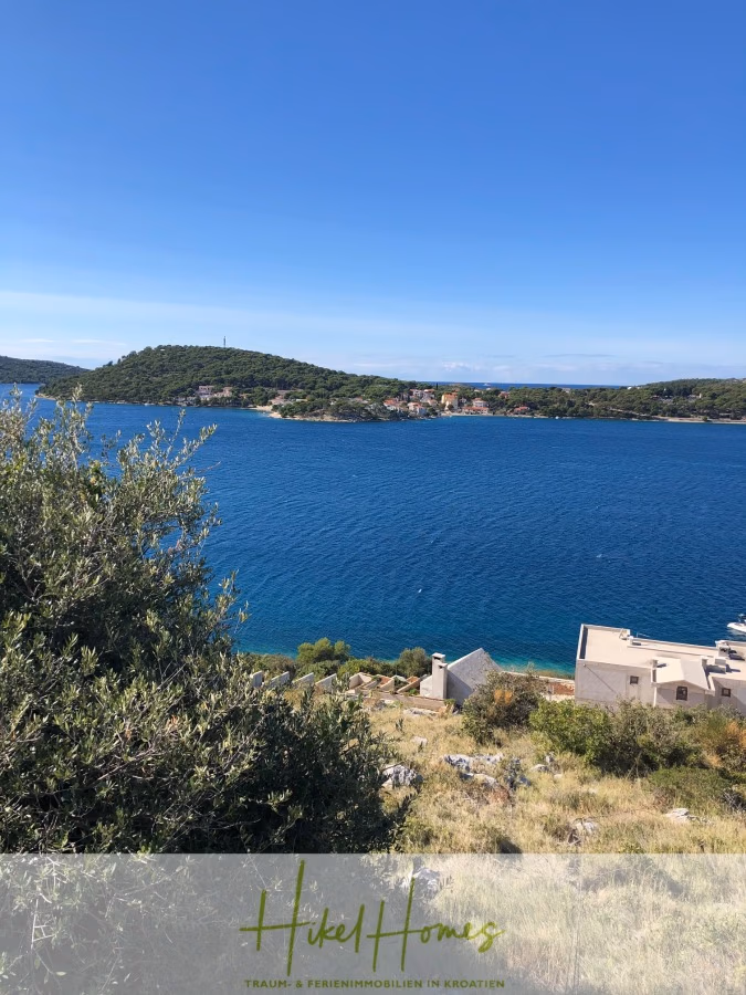 Luxus Villa Sunce / gegenüber Marina Frapa / Meerblick + direkter Meerzugang, Pool, mit 391m² WFL - Blick auf das blaue Meer mit einem kleinen Küstendorf und grünen Hügeln im Hintergrund. Im Vordergrund sind Laub und einige Gebäude zu sehen. Der Himmel darüber ist klar und blau. (42032)