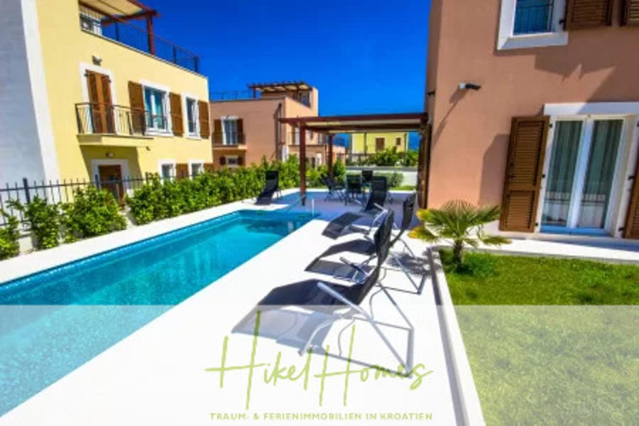 Villa im Mittelmeerstil mit 3 SZ, Pool, Dachterrasse mit Meerblick (1) - Moderne Villa mit einem kleinen privaten Pool, Liegestühlen am Pool und Balkonen, umgeben von Grün unter einem klaren blauen Himmel. Der Text "Hikel Homes" steht am unteren Rand des Bildes. (45820)