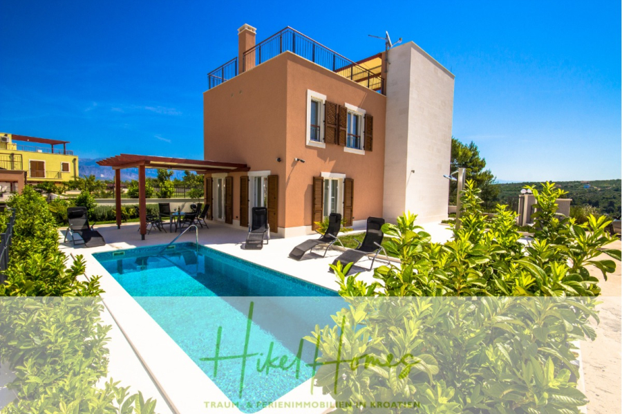 Villa im Mittelmeerstil mit 3 SZ, Pool, Dachterrasse mit Meerblick (1) - Eine moderne zweistöckige Villa mit einem kleinen Pool, Liegestühlen und Gartengrün unter einem klaren blauen Himmel; im Hintergrund sind Berge und andere Gebäude zu sehen. (45812)