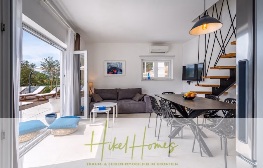 2 Meerblick Villen + freies Grundstück ideal zur Vermietungauf der Insel Dugi Otok jeweils mit Pool - Moderner Wohn- und Essbereich mit grauem Sofa, Metall- und Holztreppe, Wandfernseher und Tisch mit schwarzen Stühlen. Große Fenster und Glastüren öffnen sich zu einer Terrasse mit Loungesesseln. Heller, luftiger Raum mit abstrakter Wandkunst und einer Obstschale. (42899)