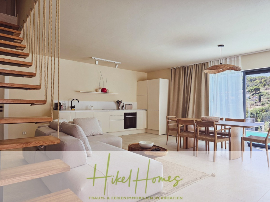 2 Meerblick Villen + freies Grundstück ideal zur Vermietungauf der Insel Dugi Otok jeweils mit Pool - Moderner, offener Wohnraum mit minimalistischer Küche, Essbereich und einem gemütlichen Sofa. Eine Holztreppe mit Seilgeländer führt in den ersten Stock. Ein großes Fenster mit Vorhängen bietet einen Blick auf das Grün draußen. (44748)