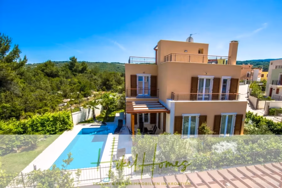Villa im Mittelmeerstil mit 3 SZ, Pool, Dachterrasse mit Meerblick (7) - Eine moderne zweistöckige Villa mit beigem Äußeren, umgeben von viel Grün. Sie verfügt über einen Swimmingpool mit blauem Deck, einen großzügigen Garten und einen Terrassenbereich. Der Himmel ist strahlend blau, und die Villa liegt eingebettet in eine üppige Hügellandschaft. (41653)