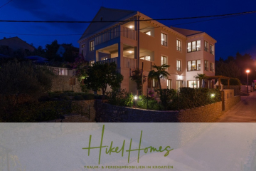 Ein modernes, gut beleuchtetes Haus mit mehreren Balkonen und großen Fenstern ist nachts von einem Garten umgeben. Der Text am unteren Rand lautet "Hikel Homes - Traum- & Ferienimmobilien in Kroatien. - Villa mit 3 großzügigen Appartements mit jeweils 3 SZ, Küche, 2 x Pool, …
