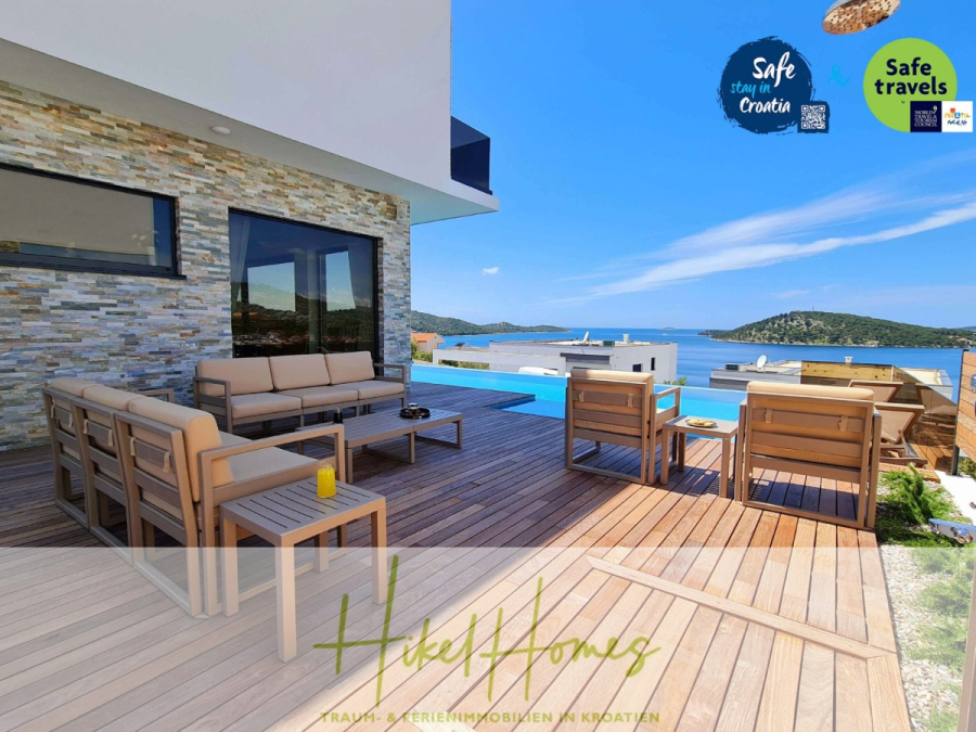 Seeview 2 von 3 | Möbilierte Luxus-Meerblick Villa mit 4 SZ, Pool, Sauna, Fitness, Jacuzzi, - Eine moderne Außenterrasse mit Holzterrasse, beigen Loungemöbeln, einem Pool und Meerblick. Logos für "Sicherer Aufenthalt in Kroatien" und "Sichere Reisen" erscheinen in der oberen rechten Ecke. (45594)