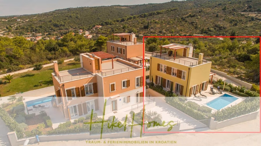 Villa im Mittelmeerstil mit 3 SZ, Pool, Dachterrasse mit Meerblick (2) - Luftaufnahme einer farbenfrohen Villa in Kroatien mit Pool und weitläufigen bewaldeten Hügeln im Hintergrund. Die Villa verfügt über mehrere Ebenen und Balkone. Im Vordergrund ist eine transparente Textüberlagerung zu sehen. (42196)