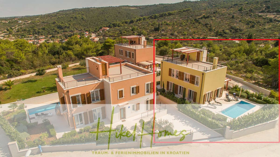 Villa im Mittelmeerstil mit 3 SZ, Pool, Dachterrasse mit Meerblick (2) - Luftaufnahme einer modernen Villa mit Swimmingpool, umgeben von Grün und Bäumen, in einem hügeligen Gebiet gelegen. Das Gebäude verfügt über mehrere Balkone und eine große Außenterrasse. (45788)