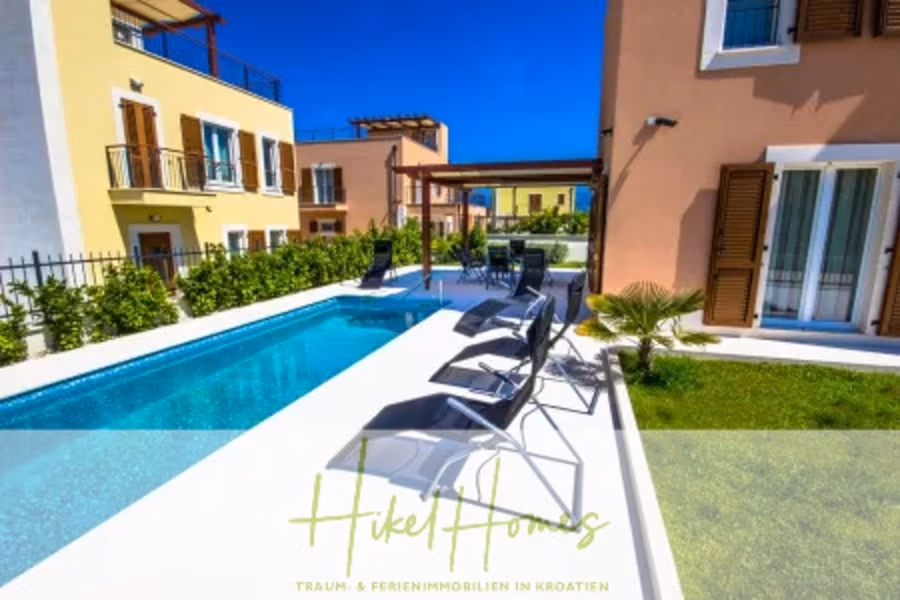 Villa im Mittelmeerstil mit 3 SZ, Pool, Dachterrasse mit Meerblick (1) - Eine moderne Villa mit elegantem Pool und Sonnenliegen, umgeben von üppigem Grün. Das Gebäude hat beigefarbene Wände und mehrere Balkone. Unten finden Sie die Texte „Hikel Homes“ und „TRAUM- & FERIENIMMOBILIEN IN KROATIEN“. (40950)