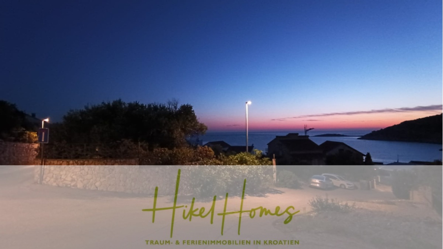 Einziehen im Sommer – Meerblick Neubau-Luxusvilla mit Einrichtung, Infinitypool & Raumkonzept - Ein beschauliches Küstendorf bei Sonnenuntergang mit Silhouetten von Häusern und Bäumen, einer Straßenlaterne und dem Meer im Hintergrund. Unten steht "Hikel Homes" und "Traum- & Ferienimmobilien in Kroatien". (44656)