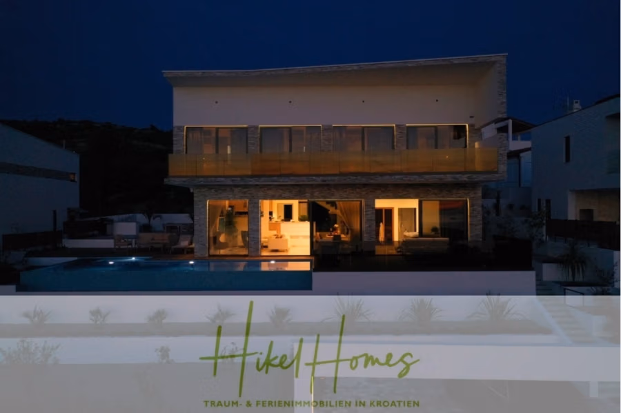 Bezugsfertige Luxus-Meerblick Villa mit 4 SZ, Pool, Sauna, Fitness, Jacuzzi, vollständig möbliert - Modernes zweistöckiges Haus mit großen Glasfenstern, die von der Innenbeleuchtung warm erstrahlen. Der Pool davor spiegelt den Nachthimmel. Logo und Text von „Hikel Homes“ werben für Ferienimmobilien in Kroatien. (42269)