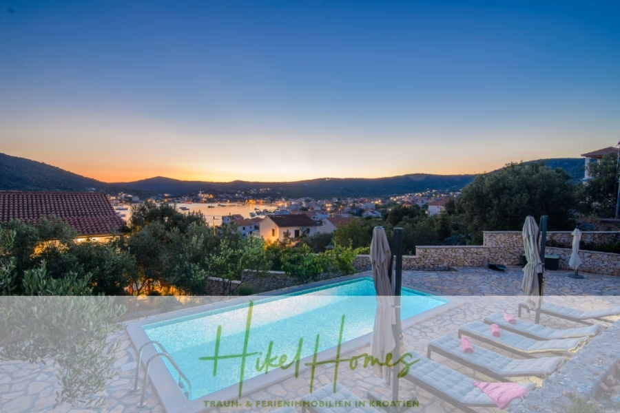 Meerblick Appartementhaus mit 3 Wohnungen, Karten, Terrassen - Blick auf eine ruhige Landschaft bei Sonnenuntergang mit Infinity-Pool und Liegestühlen, Blick auf ein malerisches Dorf zwischen sanften Hügeln und einer Bucht. Die ferne Sonne wirft einen warmen Schein über den Horizont. (40995)