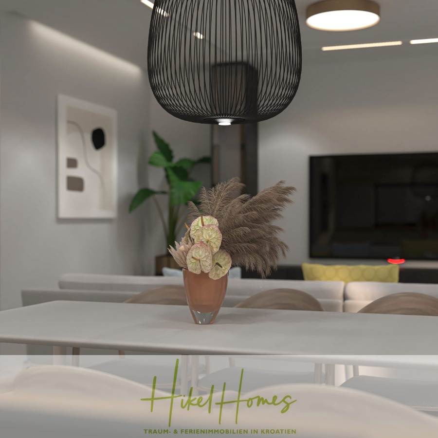 Neubau Meerblick 270m vom Meer entfernt – 3 SZ mit Bädern, Pool, Fertigstellung 2025 - Modernes Wohnzimmer mit einem weißen Tisch, einer Vase mit Pampasgras und Anthurienblüten, neutral getönten Möbeln, einem Flachbildfernseher, abstrakter Wandkunst, einer Grünpflanze und stilvoller Deckenbeleuchtung. Logo "Hikel Homes" am unteren Rand. (44687)