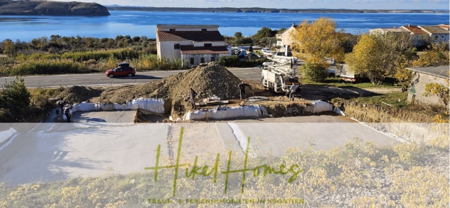 Neubau Meerblick 270m vom Meer entfernt – 3 SZ mit Bädern, Pool, Fertigstellung 2025 - Baustelle in der Nähe einer malerischen Küste mit einem roten Auto auf der Straße, einem Haus und einem gelben Herbstbaum. Ein LKW und Arbeiter sind auf der Baustelle anwesend. Im Hintergrund sind schroffe Hügel unter blauem Himmel zu sehen. (42705)
