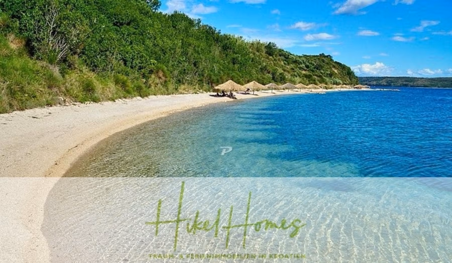 Neubau Meerblick 270m vom Meer entfernt – 3 SZ mit Bädern, Pool, Fertigstellung 2025 - Eine ruhige Strandszene mit klarem, blauem Wasser und einem Sandstrand, gesäumt von grünen Sträuchern und Bäumen. Mehrere Strohschirme sind entlang des Strandes aufgestellt. Der Text „Hill and Homes“ ist unten eingeblendet. (42707)