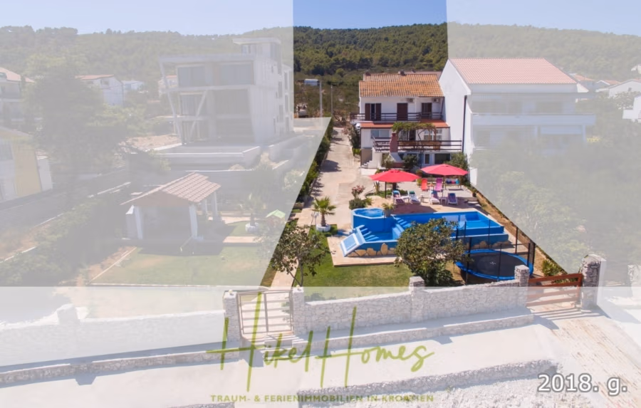 1. Reihe dirkt Meer mit 5 SZ, Pool, Jacuzzi, … auf der Insel Ciovo (bei Trogir mit 2 Brücken) - Luftaufnahme eines Wohngebiets mit Häusern, einem blauen rechteckigen Pool und roten Sonnenschirmen. Im Hintergrund sind Bäume und ein Hügel zu sehen. Der Text überlagert das Bild: „Traum- & Ferienimmobilien in Kroatien“ und „2018. ga.“. (42948)