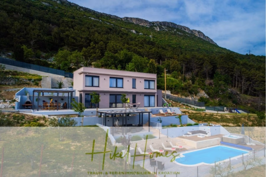 Meerblick auf 2903m² großem Grundstück in wunderbarer Alleinlage am Stadtrand von Split - Moderne Villa mit Pool und Garten vor einer Hügelkulisse. Das Haus verfügt über große Fenster, eine Pergola und Sitzgelegenheiten im Freien. Der Himmel ist teilweise bewölkt, und Bäume säumen den Hügel. Der Text lautet „Hikel Homes – Traum- & Ferienimmobilien in Kroatien“. (41445)