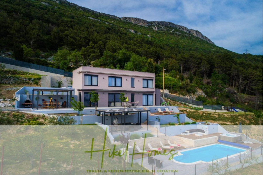Meerblick auf 2903m² großem Grundstück in wunderbarer Alleinlage am Stadtrand von Split - Moderne Villa mit Pool, Terrassen und einem überdachten Essbereich im Freien an einem bewaldeten Hang in Kroatien. Das Grundstück ist von viel Grün umgeben, mit Bergen im Hintergrund. Der Text am unteren Rand lautet "Hikel Homes". (45859)