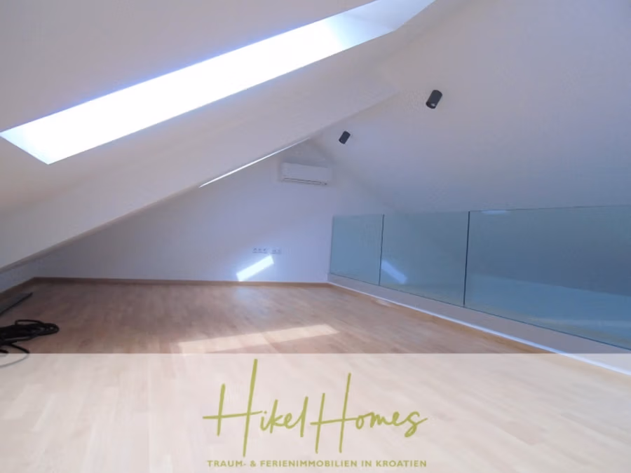 Galerie Wohnung, 3 Schlafzimmer / 70m zum Meer / Pool / 2 Bäder - Ein moderner Dachboden mit Holzboden und großem Oberlicht, das für natürliches Licht sorgt. Die nach innen geneigte Decke ist mit Strahlern ausgestattet. Eine Glaswand trennt den Raum, an der Wand ist eine Klimaanlage montiert. Spiralkabel liegen auf dem Boden. (41260)