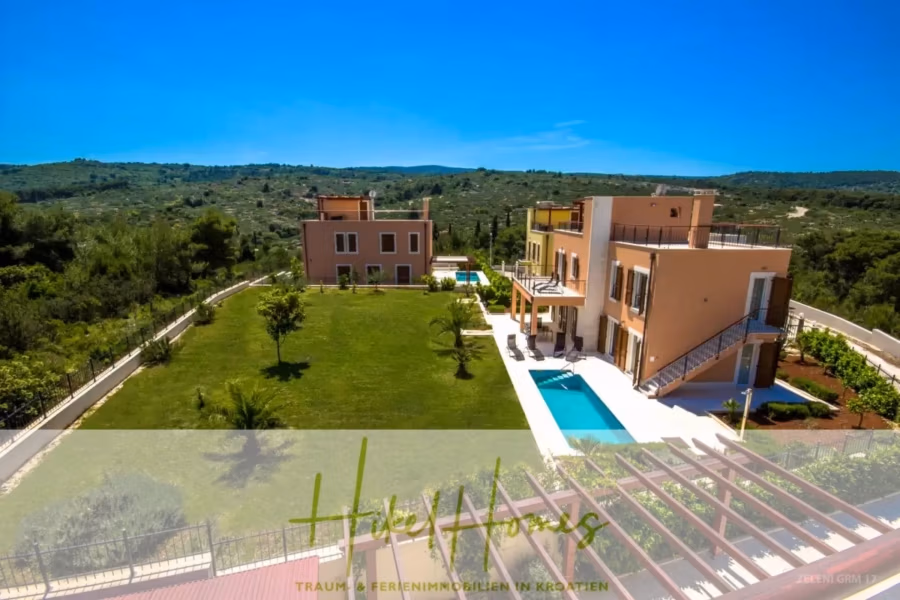 Villa im Mittelmeerstil mit 3 SZ, Pool, Dachterrasse mit Meerblick (3/4) - Luftaufnahme moderner Villen in malerischer Landschaft mit Pools und grünen Rasenflächen. Eine Villa verfügt über eine Dachterrasse. Strahlend blauer Himmel und üppiges Grün im Hintergrund. (43302)