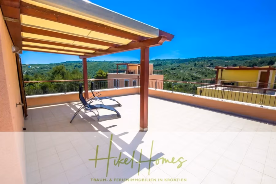 Villa im Mittelmeerstil mit 3 SZ, Pool, Dachterrasse mit Meerblick (3/4) - Eine großzügige Dachterrasse mit Fliesenboden und zwei Liegestühlen unter einer Holzpergola. Von der Terrasse aus hat man einen malerischen Blick auf grüne Hügel und blauen Himmel. Unten steht das Logo „Hikel Homes – Traum- & Ferienimmobilien in Kroatien“. (43326)
