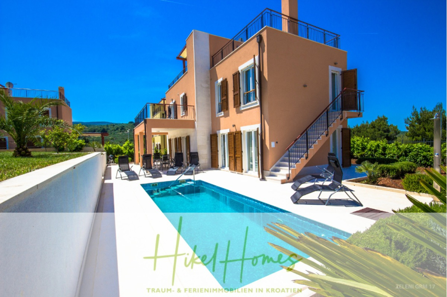 Villa im Mittelmeerstil mit 3 SZ, Pool, Dachterrasse mit Meerblick (3/4) - Moderne zweistöckige Villa mit privatem Swimmingpool, Sonnenliegen und Garten vor einer Kulisse aus grünen Hügeln und blauem Himmel. Das Anwesen wirkt einladend und gut gepflegt. (45738)