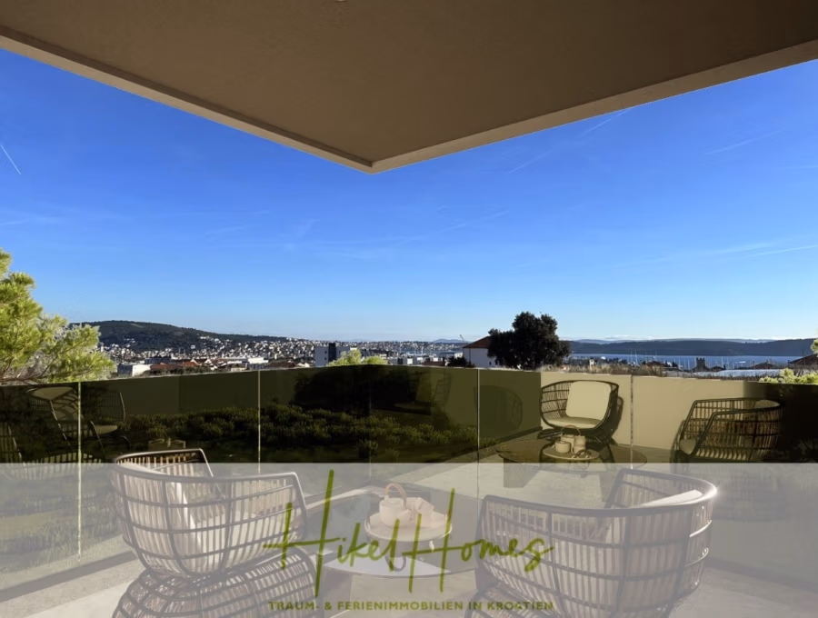 Meerblick 67m² Neubauwohnung mit 2 Schlafzimmer, Balkon und Südausrichtung - Ein moderner Balkon mit Korbstühlen und Glasgeländer bietet einen Panoramablick auf die Stadtlandschaft, umgeben von Grün und Hügeln unter einem klaren blauen Himmel. Unten ist das Logo von Hikel Homes zu sehen. (41293)