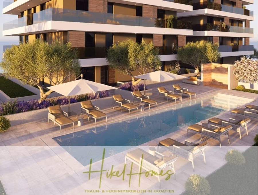 1. Reihe hochwertige Neubau-Meerblick Wohnung mit 1 SZ, Terrasse und Gemeinschaftspool (S2B) - Moderner Außenpoolbereich mit Sonnenliegen und Sonnenschirmen, umgeben von üppigem Grün. Im Hintergrund ist ein modernes mehrstöckiges Gebäude mit Balkonen zu sehen. Der Bereich ist in warmes Sonnenlicht getaucht. Unten steht „Hikel Homes“. (43016)