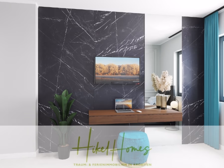 Meerblick 60m² Neubauwohnung mit 2 Schlafzimmer, Balkon und Südausrichtung - Modernes Interieur mit einem eleganten, wandmontierten Holzschreibtisch vor einer schwarzen Marmorwand. Darüber hängt ein gerahmtes Landschaftsfoto. Auf dem Schreibtisch stehen ein Laptop und eine Vase mit Pampasgras. Ein großer Spiegel reflektiert einen Teil des Raumes. Darunter steht ein bequemer blauer Hocker. (41345)