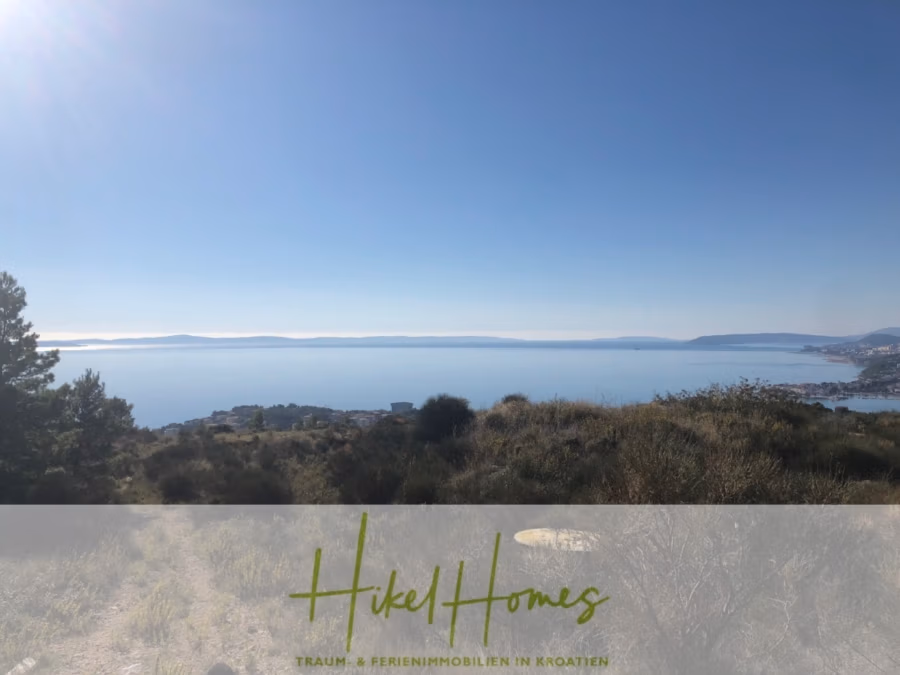 511m² Traumvilla auf über 3100m² großem unverbaubaren Meerblick Grundstück – eigene Auffahrt - Eine ruhige Küstenlandschaft mit Panoramablick auf das klare, blaue Meer unter wolkenlosem Himmel. Grünes und zerklüftetes Gelände stehen im Vordergrund. Der Blick erstreckt sich über das Wasser bis hin zu fernen Landformen. (41945)