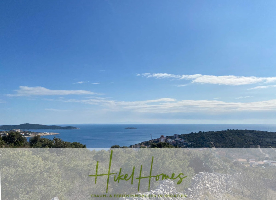 805m² Bauland in Panoramahanglage mit traumhaften Rundumblick aufs Meer und die vorgelagerten Inseln - Eine malerische Küstenlandschaft mit klarem blauen Himmel, fernen Inseln, glitzerndem Meer und grünen Hügeln. Der Text "Hikel Homes" und "TRAUM- & FERIENIMMOBILIEN KROATIEN" erscheint am unteren Rand. (44615)