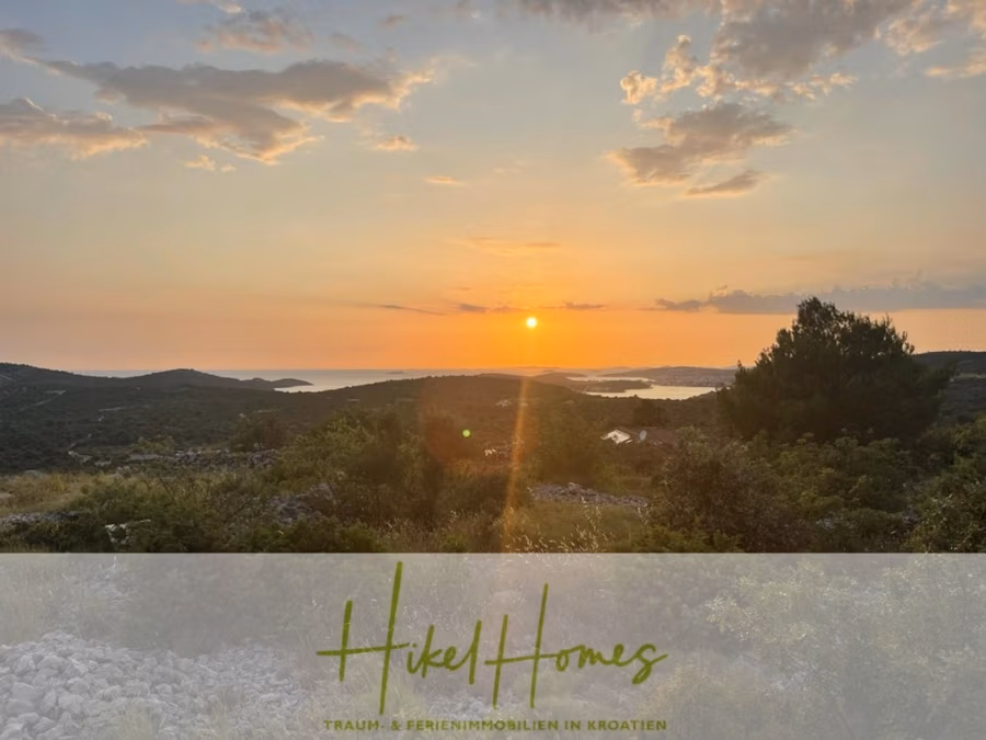 Prämiertes Architekturprojekt – Meerblick Luxus auf 490m² auf 1800m² Grund mit 2 Pools, Bar, Lounge - Sonnenuntergang über einer hügeligen Landschaft mit dem Meer in der Ferne. Der Himmel ist orange und rosa mit vereinzelten Wolken. Im Vordergrund sind Bäume und Büsche zu sehen. Unten steht: „Hikel Homes – Traum- & Ferienimmobilien in Kroatien.“. (41184)