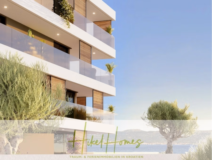 1. Reihe hochwertige Neubau-Meerblick Wohnung mit 2 SZ, Terrasse und Gemeinschaftspool (S2A) - Modernes Apartmentgebäude mit Glasbalkonen und viel Grün mit Blick aufs Meer. Ein Baum auf dem Dach im Vordergrund und Berge im Hintergrund verstärken die ruhige Atmosphäre. Der Text unten lautet: „Hikel Homes Traum- & Ferienimmobilien in Kroatien.“. (42749)