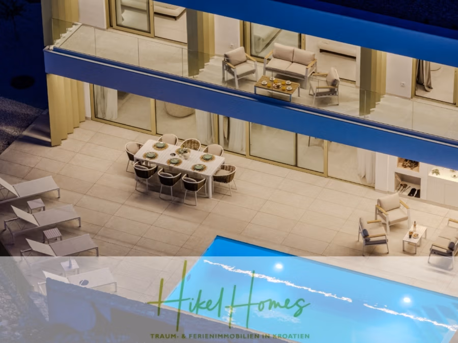 Schlüsselfertige Meerblick Villa SEA in Sutivan (Insel Brac) – 3 SZ + Bad, Pool, Sommerküche, … - Blick vom Dach einer luxuriösen, modernen Villa mit großem Pool. Die Terrasse verfügt über einen Esstisch mit acht Stühlen. Gepolsterte Sonnenliegen und eine gemütliche Sitzecke sind ebenfalls vorhanden. Das Bild trägt den Text „Hikel Homes: Traum- und Ferienimmobilien in Kroatien“. (42990)