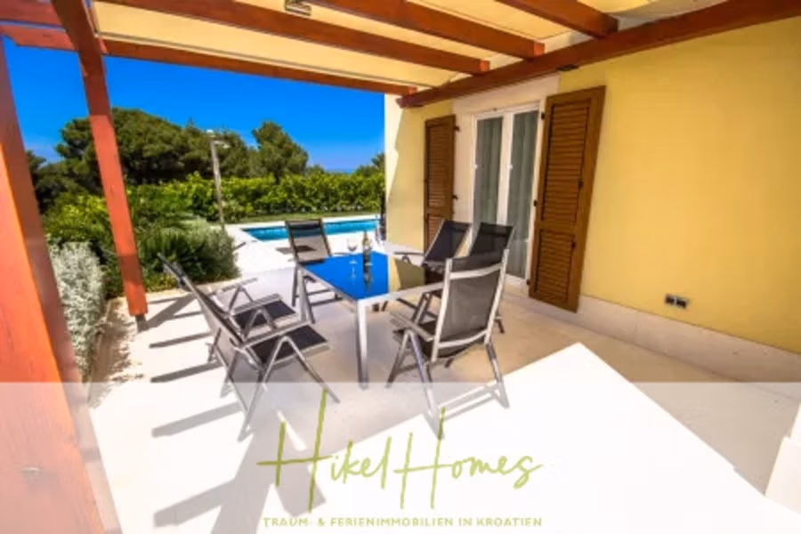 Villa im Mittelmeerstil mit 3 SZ, Pool, Dachterrasse mit Meerblick (2) - Außenterrasse mit Esstisch und sechs Stühlen unter einer Pergola. Der Bereich grenzt an einen Swimmingpool und ist von viel Grün umgeben. Glasschiebetüren mit Fensterläden führen in den Innenbereich. Im Hintergrund ist der blaue Himmel zu sehen. (41870)