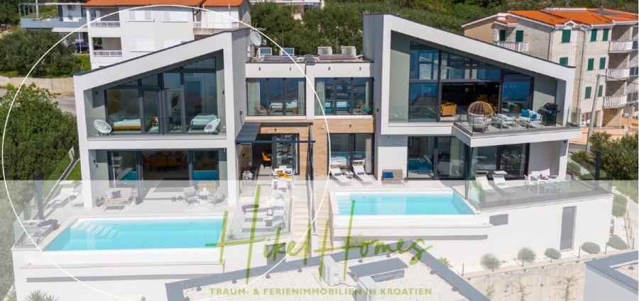 Sofort einziehen! Meerblick Villa CECILIE Infinity Pool, 3 SZ, Sommerküche, Videoraum mit PS5, …. - Luftaufnahme von zwei modernen Villen mit großen Fenstern, privaten Pools und Lounge-Bereichen im Freien, gelegen an einem Hang in Kroatien. Der Text lautet: „Hife Homes, Traum- & Ferienimmobilien in Kroatien.“. (43889)