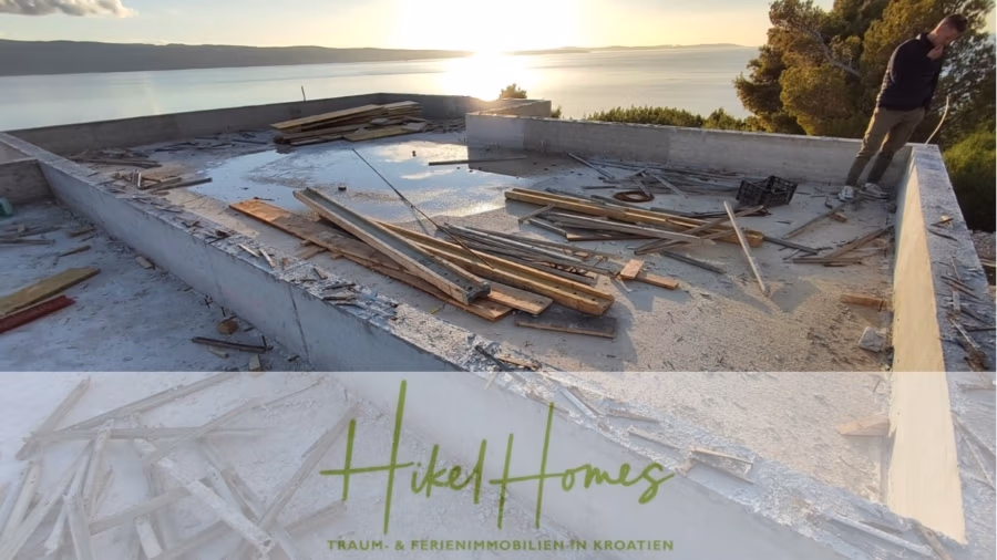 Schlüsselfertige – großzügige Meerblick Villa in ruhiger Lage, 4 SZ, 4 Bäder, Pool, Jacuzzi, … - Baustelle mit Betonfundament und Blick auf ein Gewässer bei Sonnenuntergang. Holzbretter und Baumaterialien liegen verstreut auf dem Boden. Unter dem Bild steht der Text „Hikel Homes“ mit einem Slogan über Immobilien in Kroatien. (41021)