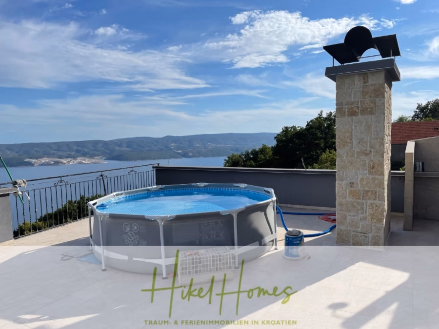 Meerblick aus perfekter Höhenlage mit 3 Schlafzimmern - Auf der Dachterrasse befindet sich ein runder, oberirdischer Pool mit Blick auf ferne Hügel und ein Gewässer. Neben dem Pool befindet sich ein Steinkamin, und ein Balkon mit Metallgeländer umgibt den Raum. Der Himmel ist teilweise bewölkt. (41477)