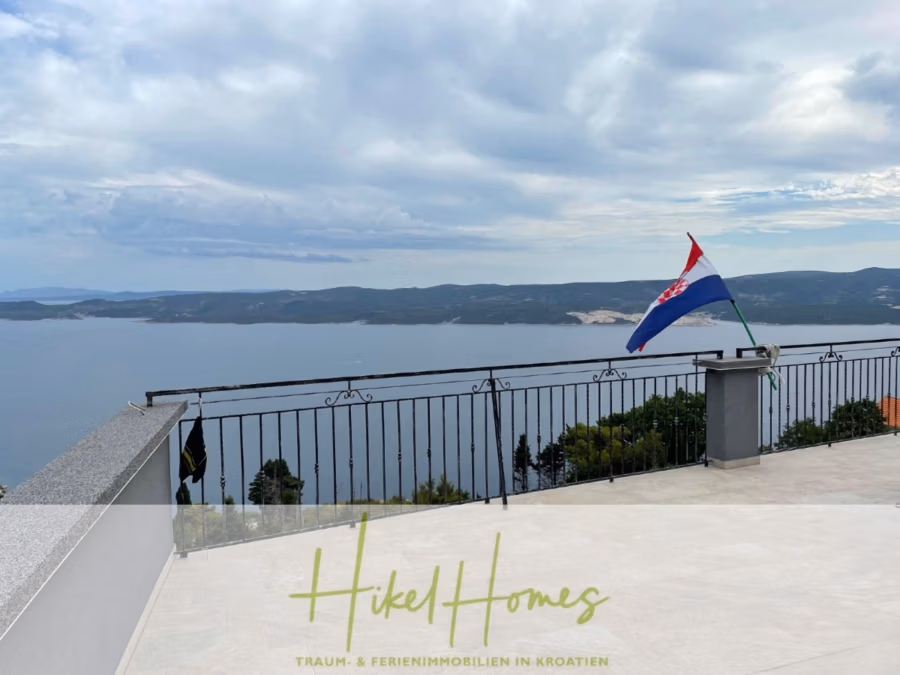 Meerblick aus perfekter Höhenlage mit 3 Schlafzimmern - Aussichtsplattform mit kroatischer Flagge und Blick auf ein weites Gewässer und ferne Hügel unter bewölktem Himmel. Die Plattform verfügt über ein Metallgeländer, darunter ist Grün zu sehen. Der Text lautet: „Hike Homes – Traum & Ferienimmobilien in Kroatien.“. (41473)