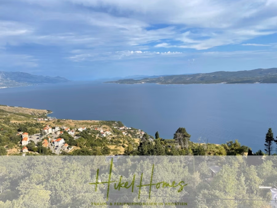 Meerblick aus perfekter Höhenlage mit 3 Schlafzimmern - Malerische Küstenansicht mit üppig grünen Hügeln, verstreuten Häusern und weitem blauen Wasser unter einem teilweise bewölkten Himmel. Am unteren Bildrand ist ein Wasserzeichen mit Text sichtbar. (41490)
