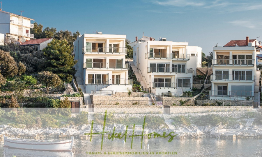 Villa Ana – 250m² WFL in 1. Reihe zum Meer / 4 SZ / Neubau / Sofort bezugsfertig - Drei moderne, weiße Villen mit großen Balkonen direkt am Meer in Kroatien, umgeben von viel Grün und angedockten Booten. Textüberlagerung lautet: "Hide Homes Traum-Ferienimmobilien in Kroatien. (46513)