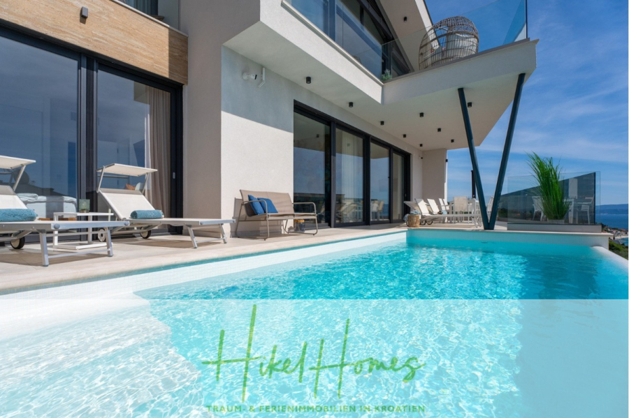 Direkt einziehen Meerblick Villa NATALIA mit Infinity Pool, 3 SZ, Sommerküche, … - Moderne Villa mit großen Glasfenstern, Sonnenliegen und privatem Pool an einem sonnigen Tag. Vom Pool aus hat man einen malerischen Ausblick. Am unteren Bildrand ist der Text „Hikel Homes“ zu sehen. (43860)
