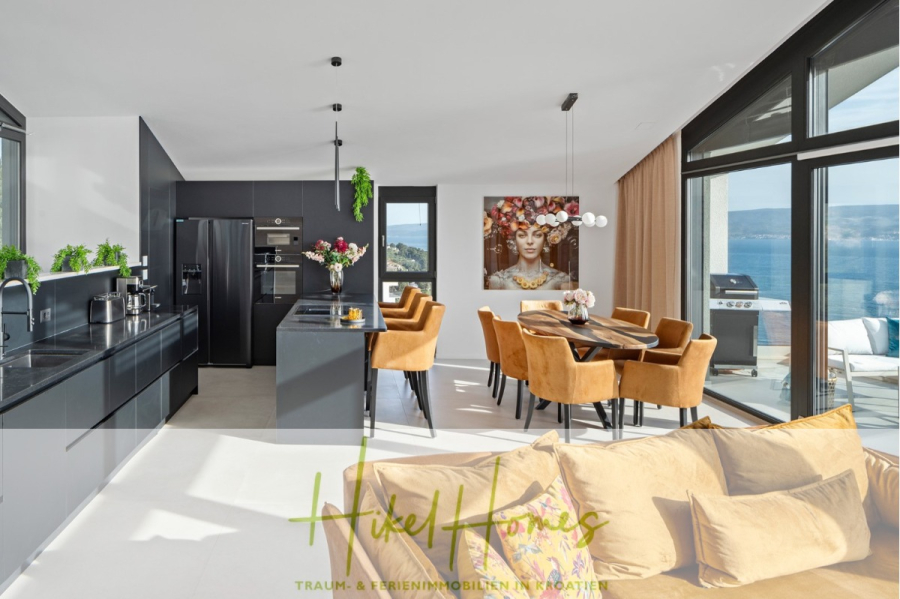 Direkt einziehen Meerblick Villa NATALIA mit Infinity Pool, 3 SZ, Sommerküche, … - Moderne offene Küche und Essbereich mit schwarzen Schränken, hellbraunen Polsterstühlen, großen Fenstern mit Meerblick und zeitgenössischer Kunst an der Wand; Sonnenlicht füllt den hellen Raum. (43870)