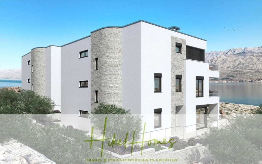 Nahe Zadar – Luxus-Villa in 2. Reihe zum Meer mit 4 SZ, Pool, Sauna, Fitness & Jacuzzi - Modernes weißes Apartmentgebäude mit Steinakzenten, großen Fenstern und Balkonen mit Blick auf ein Gewässer und die Berge unter einem klaren blauen Himmel. Olivenbäume und Grünflächen umgeben das Grundstück. (45966)